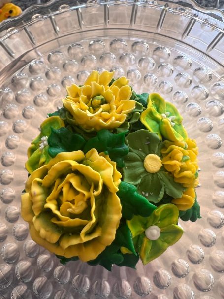 This cupcake has team spirit with Green and Gold flowers.  Perfect for cheering on your favorite team or celebrate a graduation!
